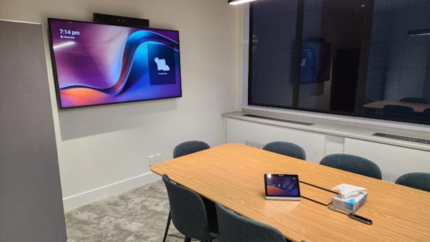 Boardroom setup showing a single screen with control surface on the table